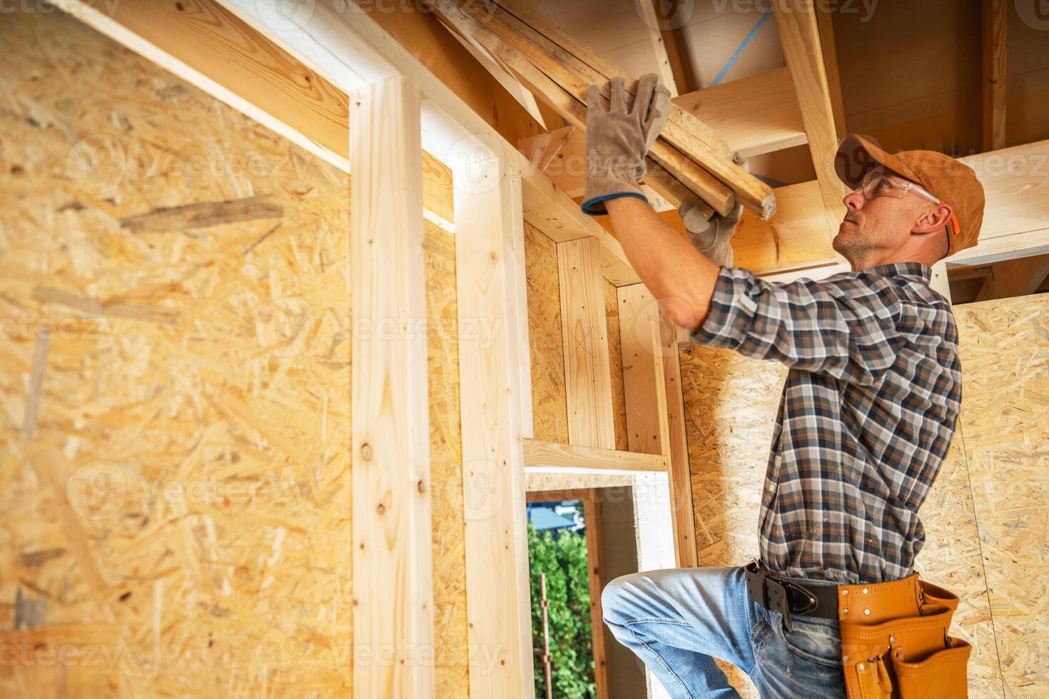 A Carpenter Installs Wooden Beams in a Partially Constructed Interior During Daytime Renovations photo