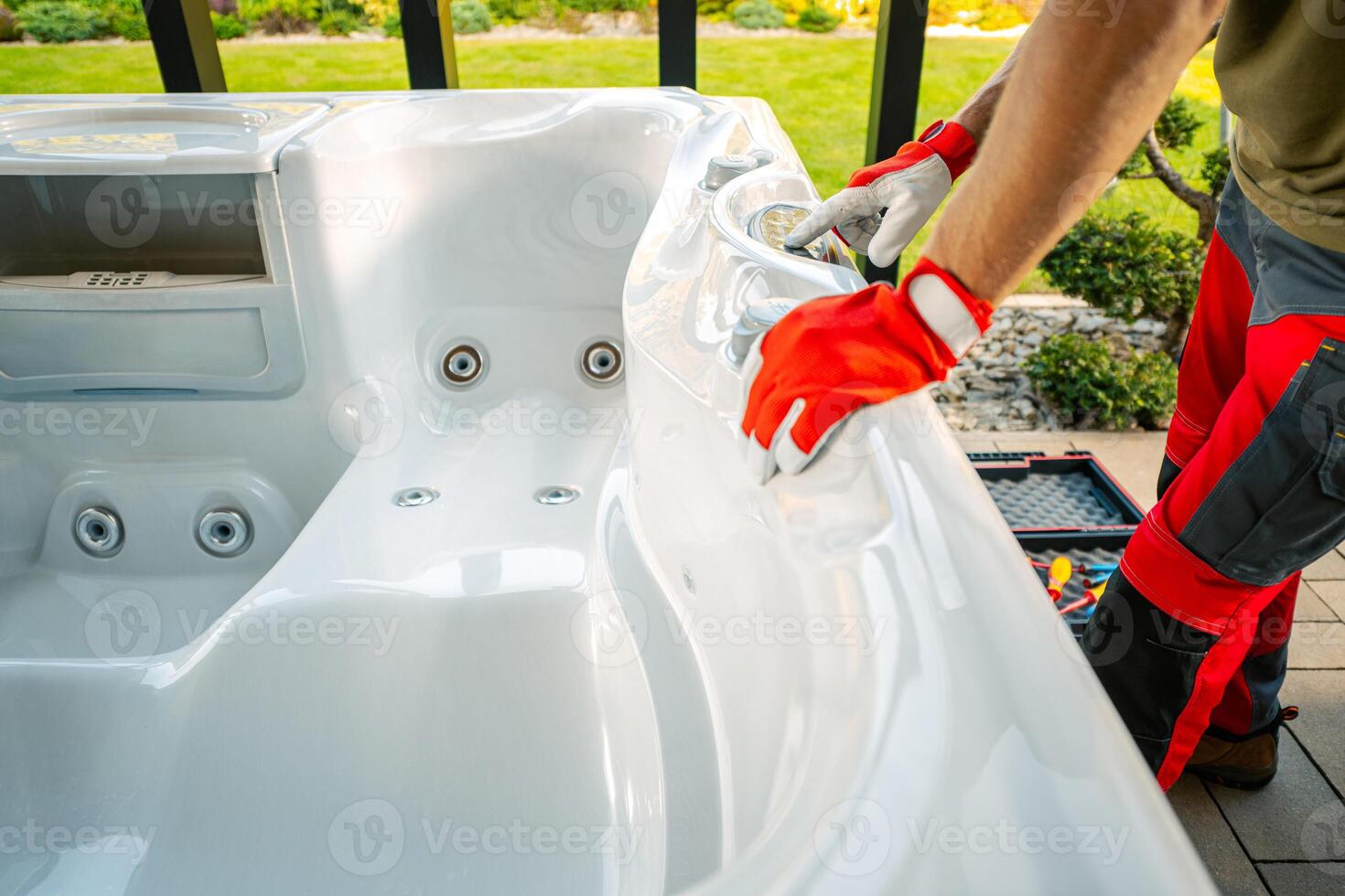 Technician Performing Maintenance on a Hot Tub at a Residential Backyard During the Afternoon photo
