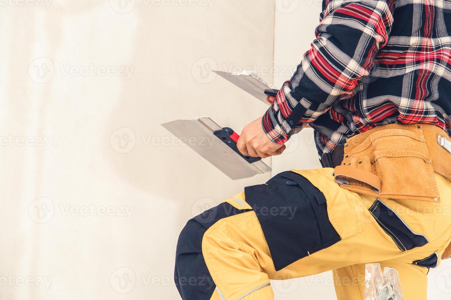 Worker Adds Final Touches to Drywall in Modern Home Renovation During Daylight photo