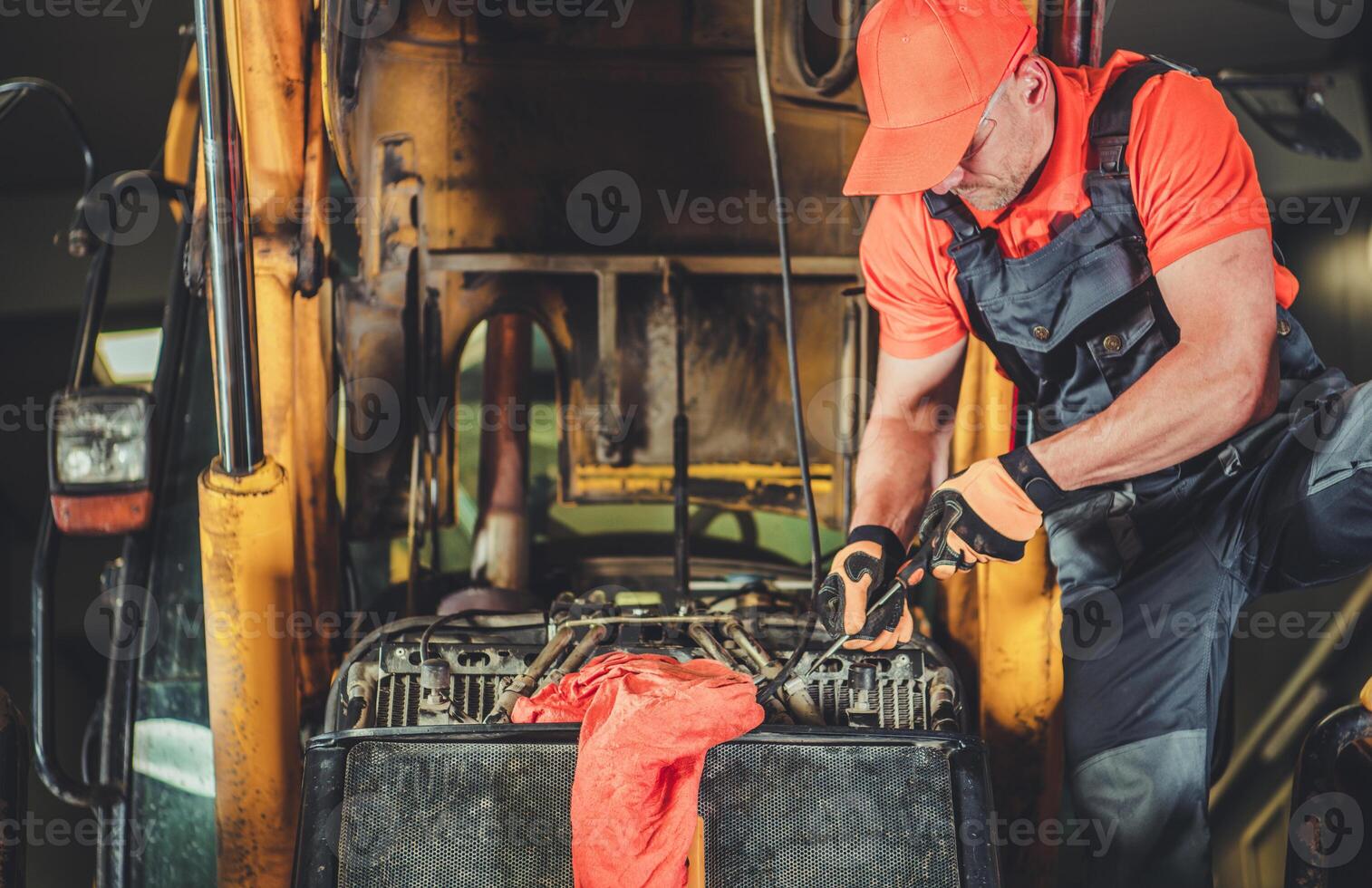 Mechanic Repairing Heavy Machinery in Workshop During Daytime With Focus on Engine Maintenance photo
