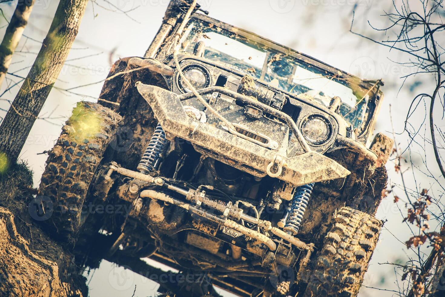 Off-road Vehicle Climbing a Muddy Hill During a Daytime Adventure in the Forest photo