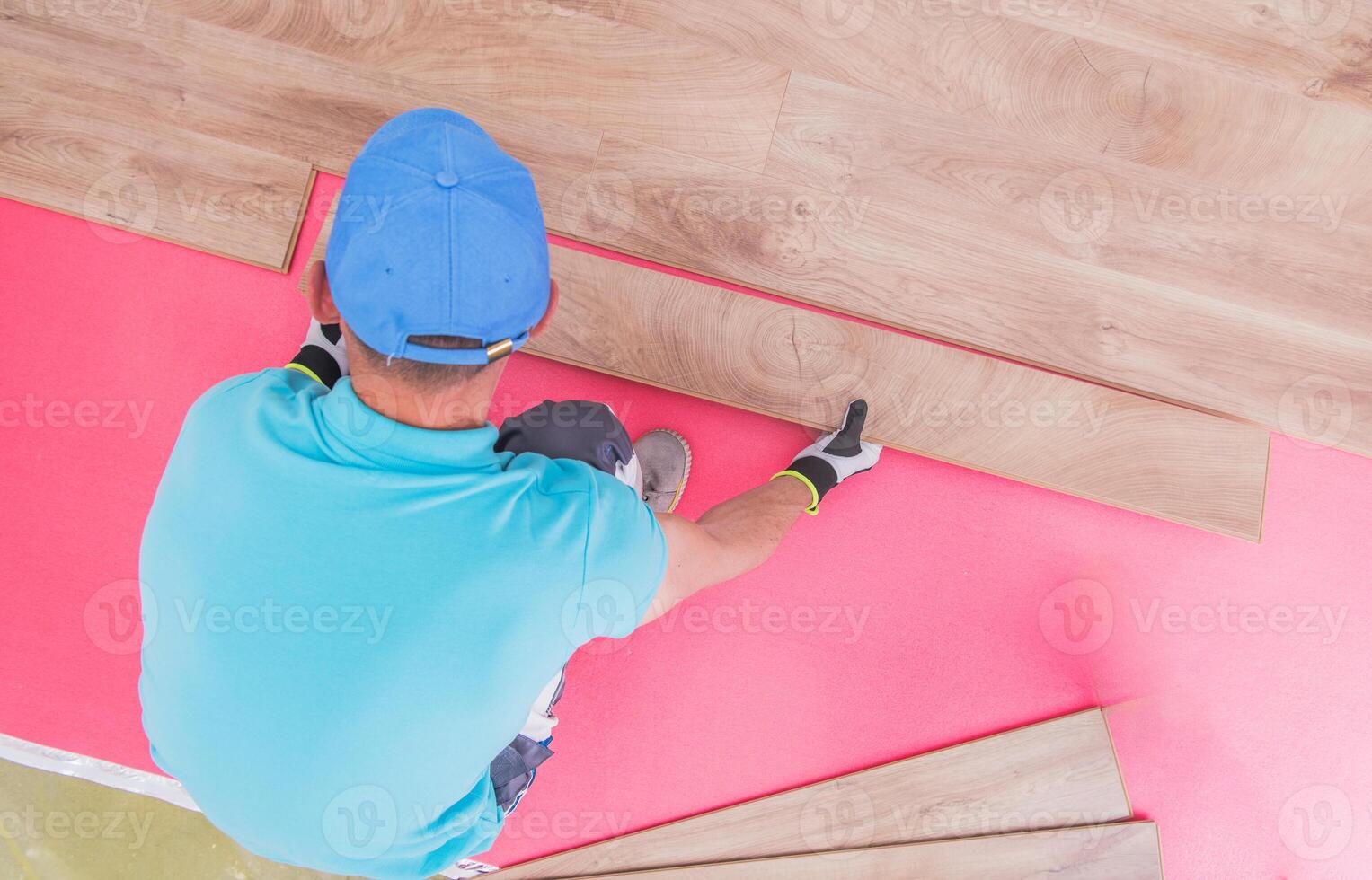 Man Installing Laminate Flooring in a Bright Room During Daylight Hours photo