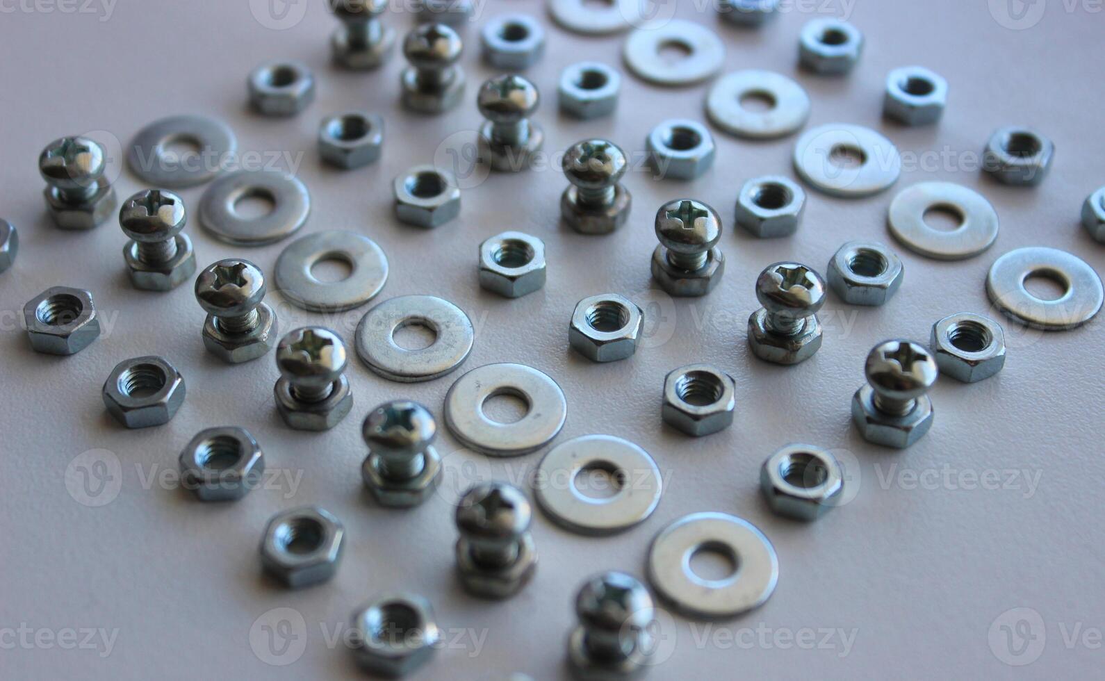 Macro photo of square laid out from separate rows of metal ironware products on white workbench