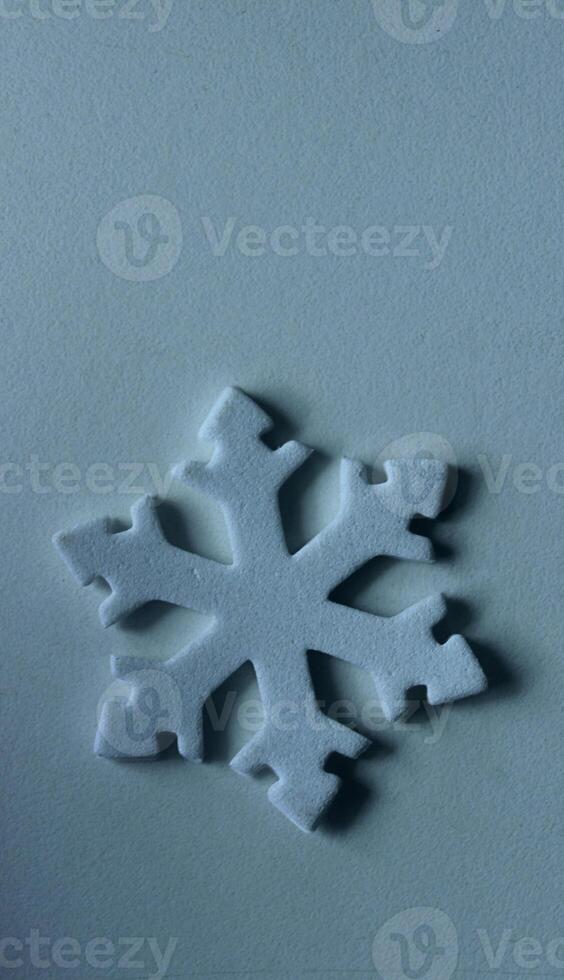Vertical Winter Background With Toy Snowflake On Light Blue Surface Similar To Ice. Flat Lay Image Of Isolated 3D Snowflake On Frozen Surface photo