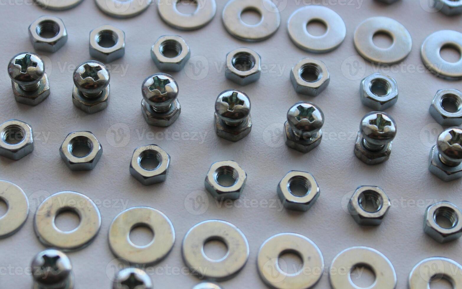 Lines Of Metallic Hardware Items On A White Surface Of Workbench. Macro Shot Stock Photo For Hardware Backgrounds