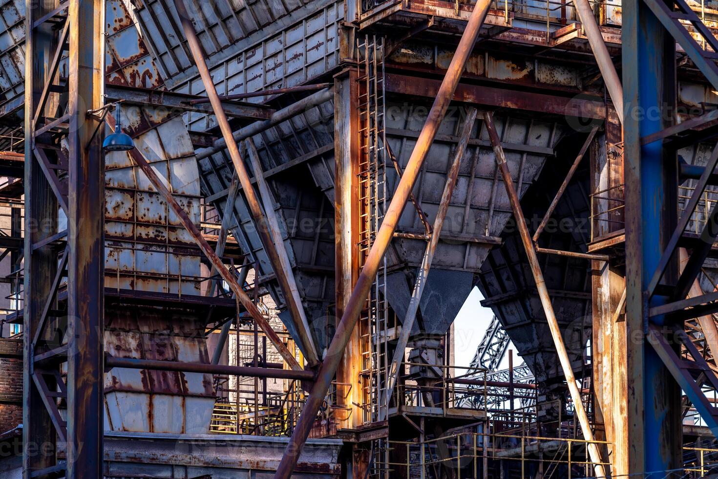 Rusty industrial building with crumbling facade showing decaying metal structure photo