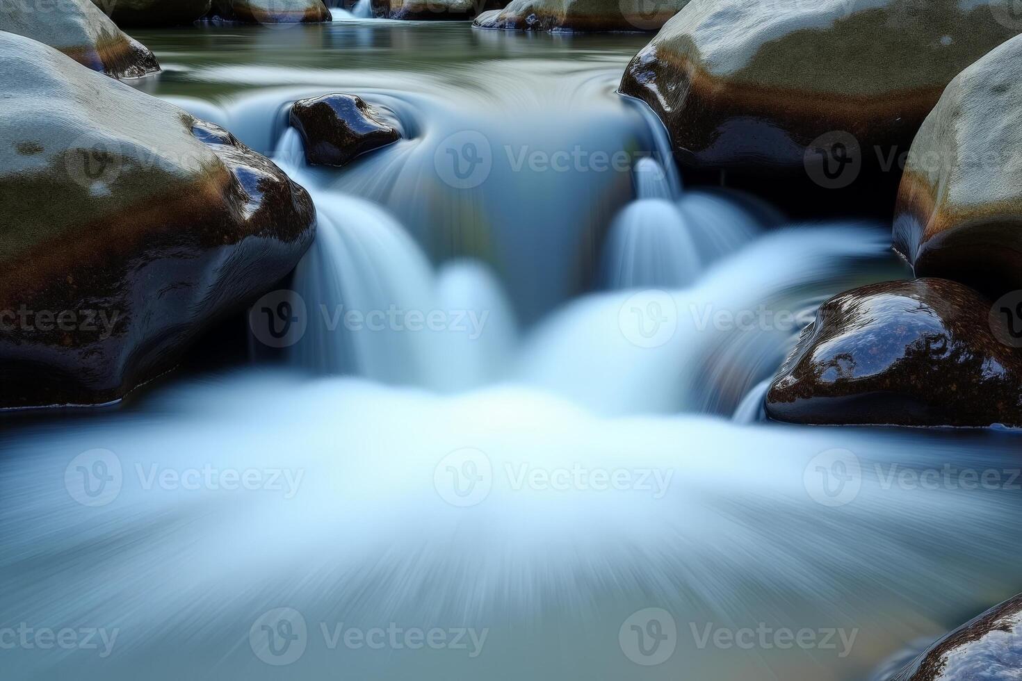 A stream of water flowing over rocks in a river photo