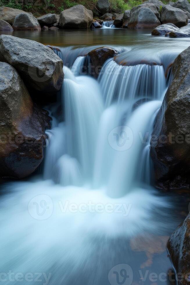 A waterfall flowing over rocks in a river photo