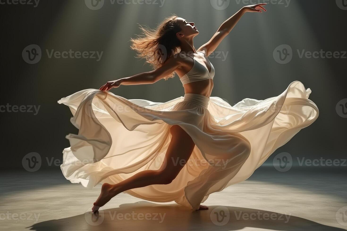 Dancer in white dress dancing in the light photo