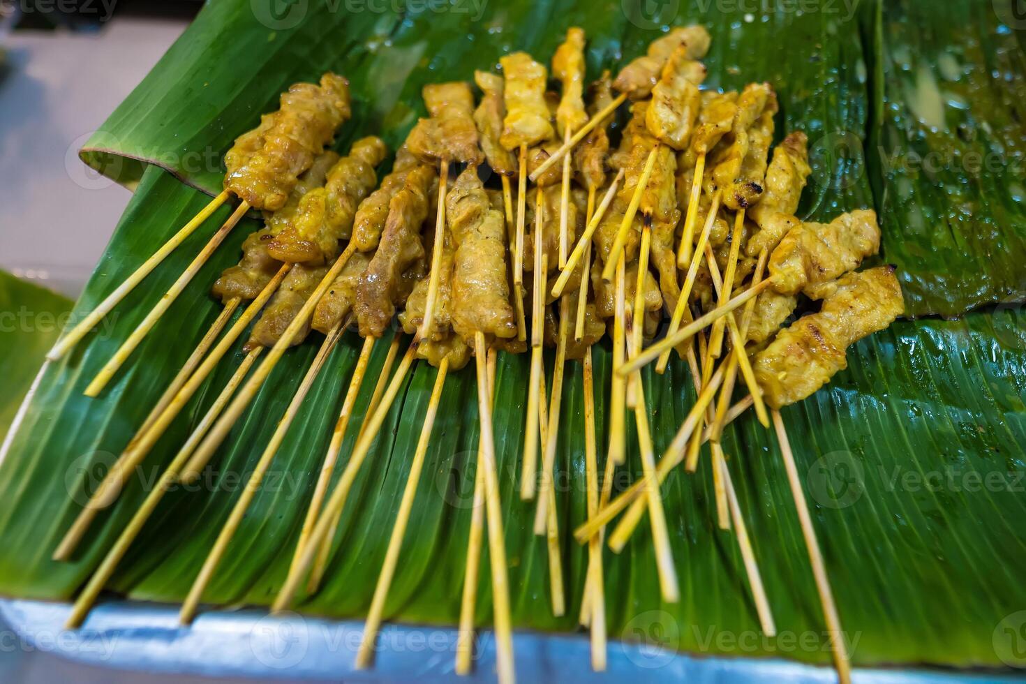 Authentic Thai Pork Satay with Creamy Peanut Sauce, Topped with Shallots and Spicy Fresh Chilies photo