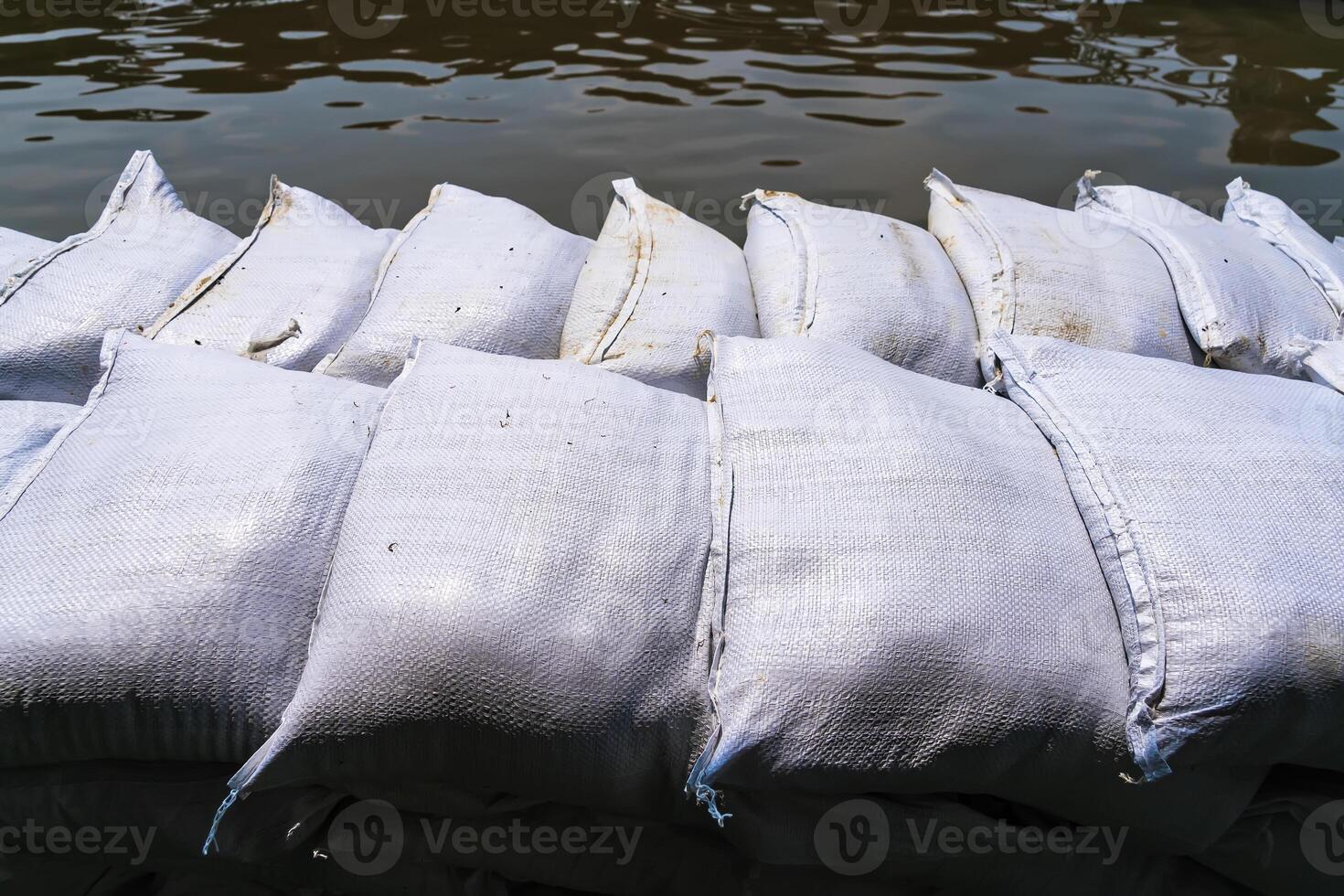 Flood Prevention Sandbags Forming a Defensive Wall Along the River to Shield Against Overflow photo