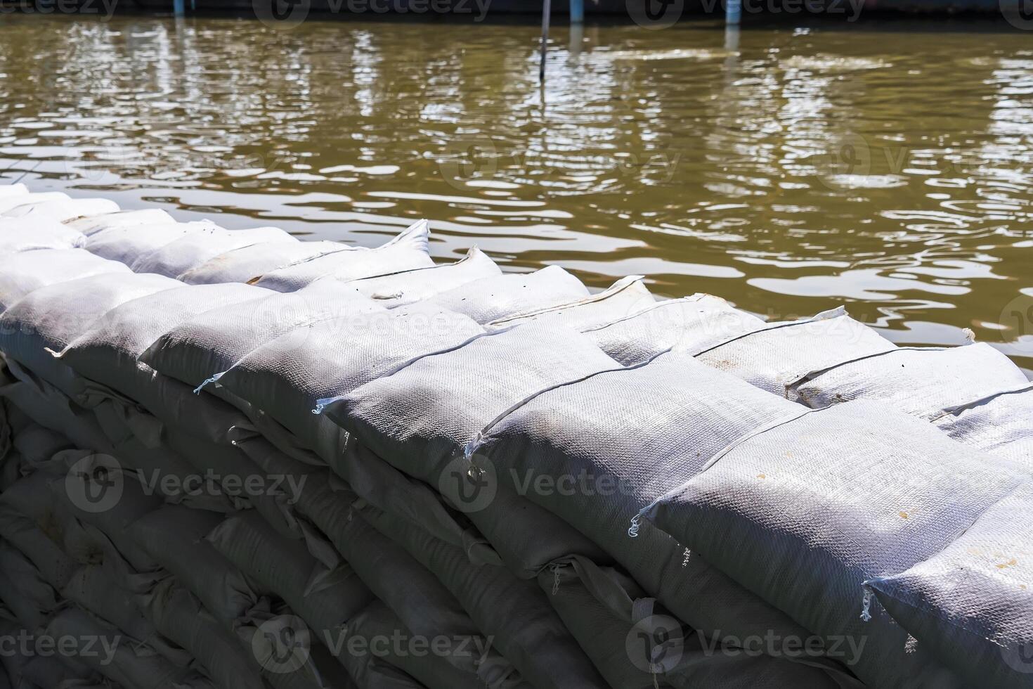 Flood Prevention Sandbags Forming a Defensive Wall Along the River to Shield Against Overflow photo