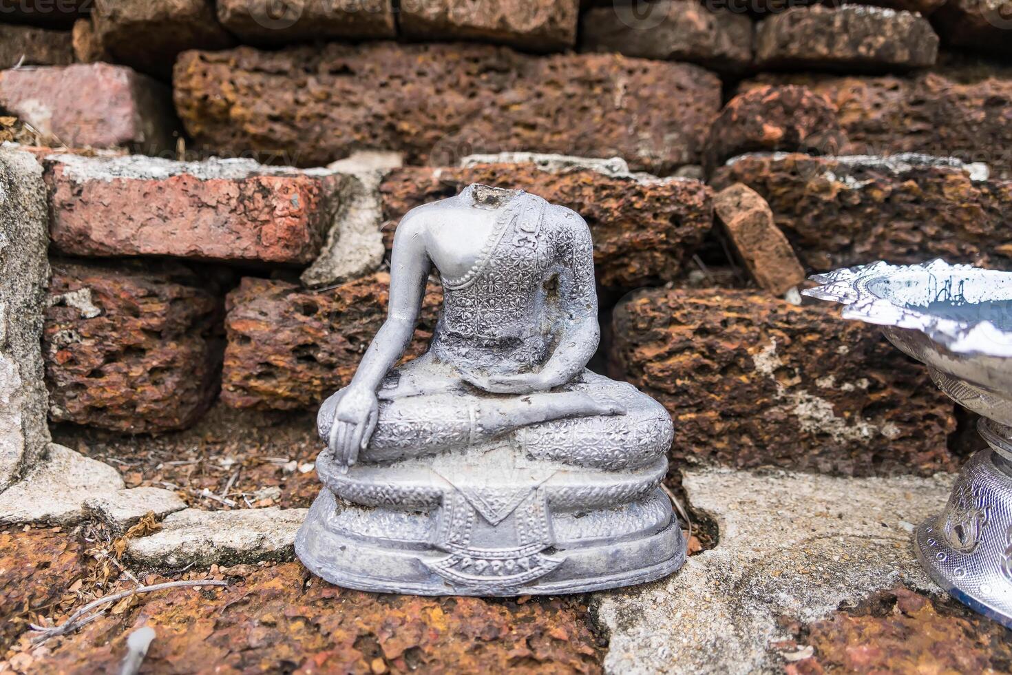 Ancient Headless Buddha Statue Amidst Weathered Bricks - A Symbol of Time's Passage and Cultural Heritage photo