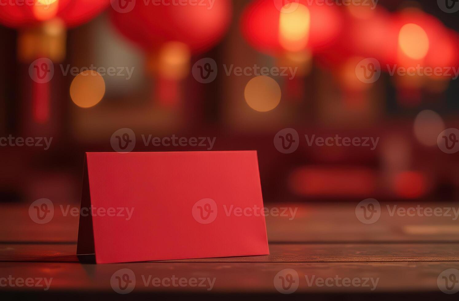 Red envelope on wooden table with lanterns in background. Chinese New Year. photo