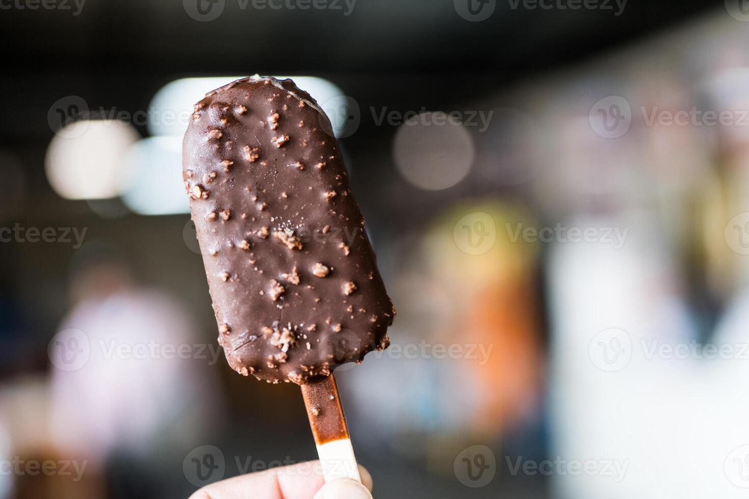 Chocolate popsicle ice cream bar with crushed peanut nuts. photo