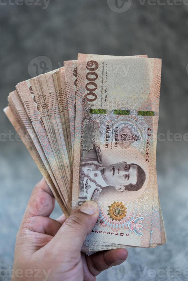 Holding a lot of 1,000 Baht Thailand banknote photo