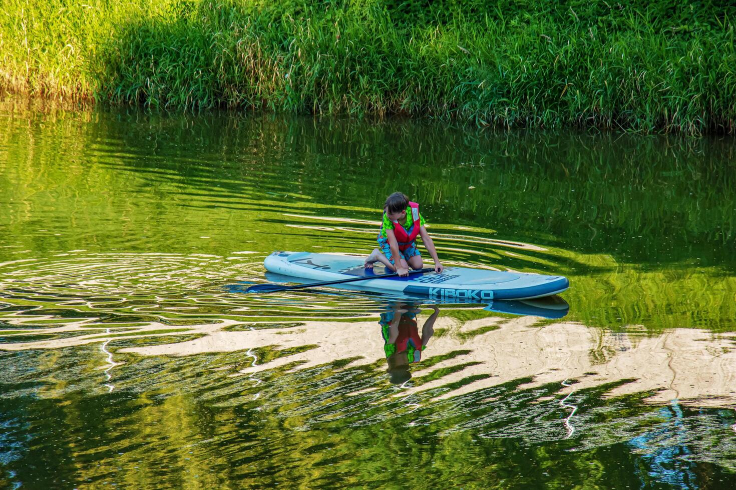 Nitra, Slovakia - 06.15.2022 A teenage boy is sailing in a canoe on the Nitra river. photo