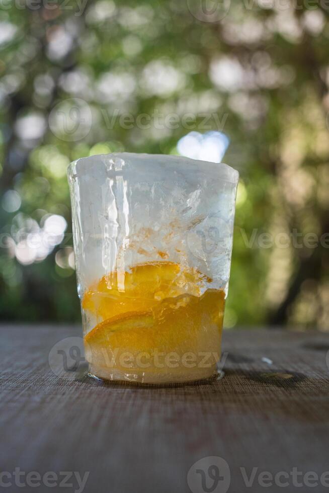 Frozen ice with slice orange fruit inside cup shape from the freezer refrigerator photo