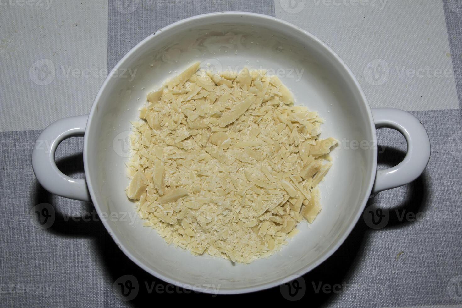 Cocoa butter background, top view, texture. Cocoa butter is one of the ingredients in making chocolate at home. Close-up of crushed cocoa butter, top view. photo