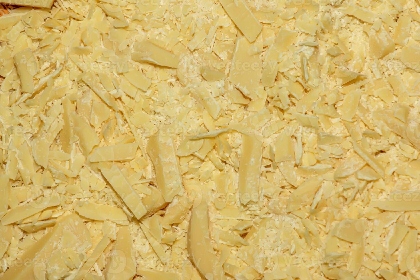 Cocoa butter background, top view, texture. Cocoa butter is one of the ingredients in making chocolate at home. Close-up of crushed cocoa butter, top view. photo