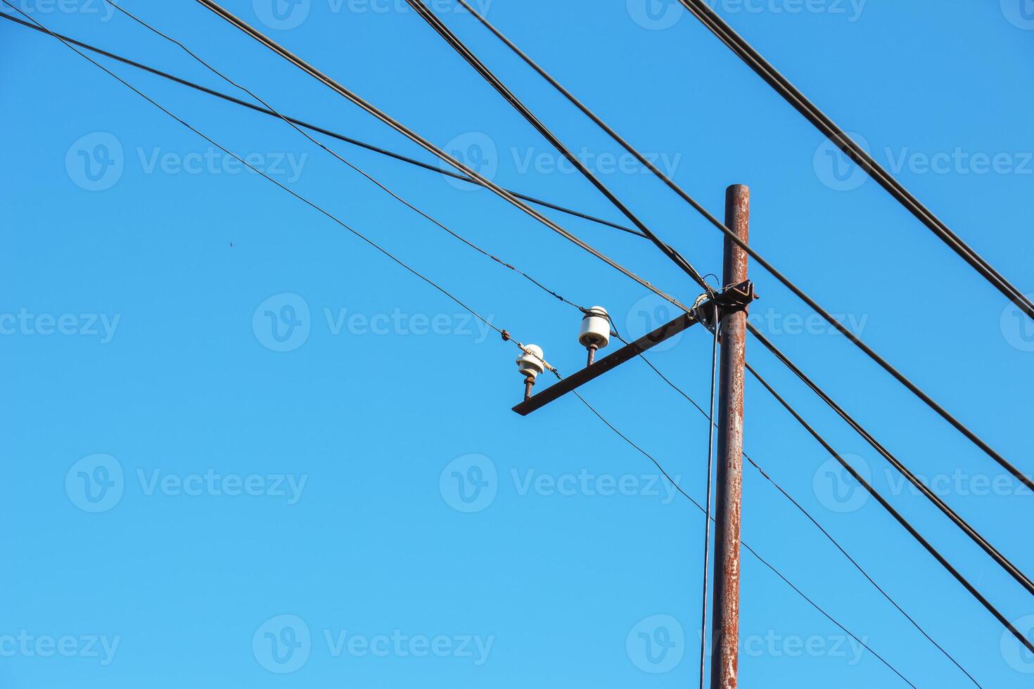 Electric pole power lines outgoing electric wires againts on cloud blue sky. photo