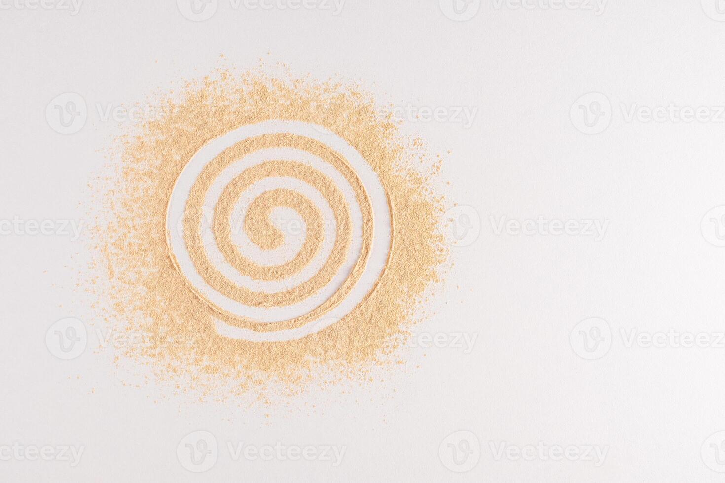 Dry loose powder of natural tone is scattered on a white background in a spiral. Abstract cosmetic background. A copy space. top view. Sample, Mockup photo