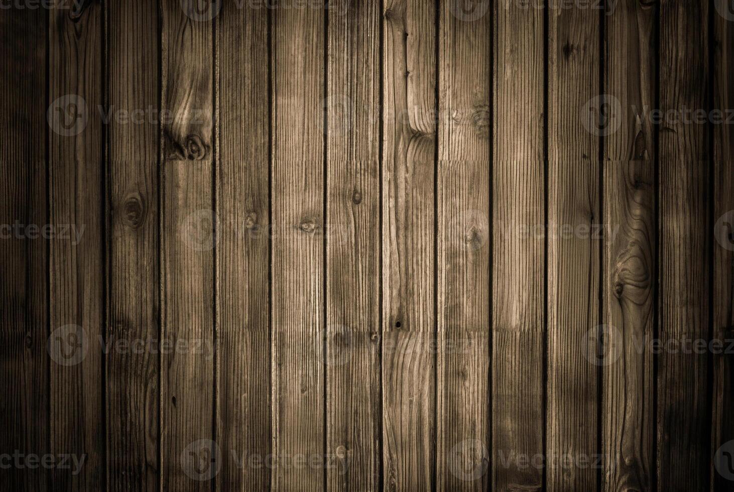 Rustic wooden plank wall with dark tones and visible vertical grain texture, ideal for backgrounds and wood-themed designs. photo