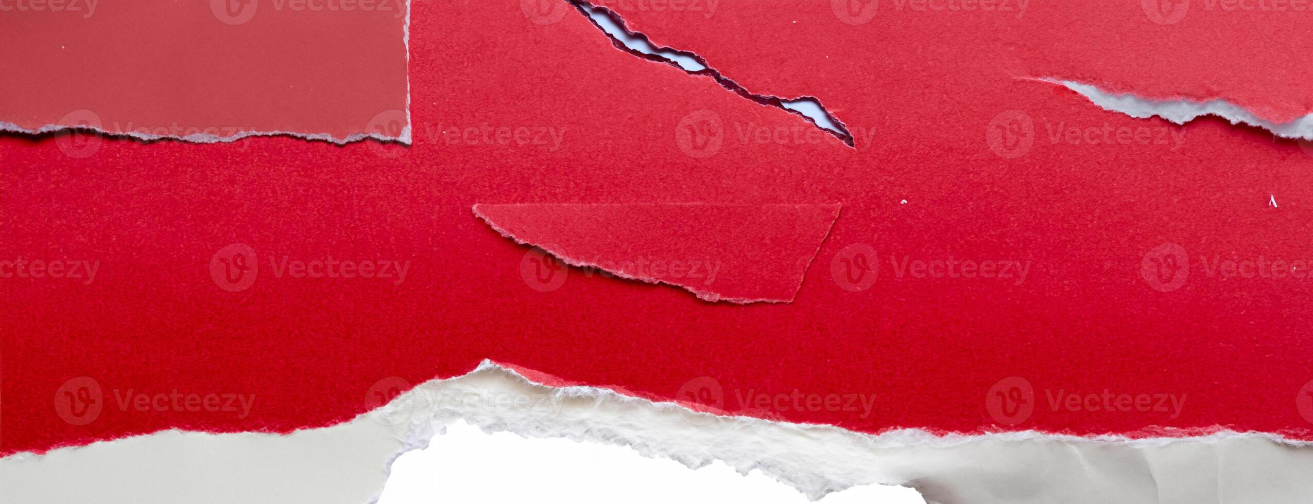 Close-up of a torn red paper edge on a white background, showing a rough texture and contrasting colors. photo