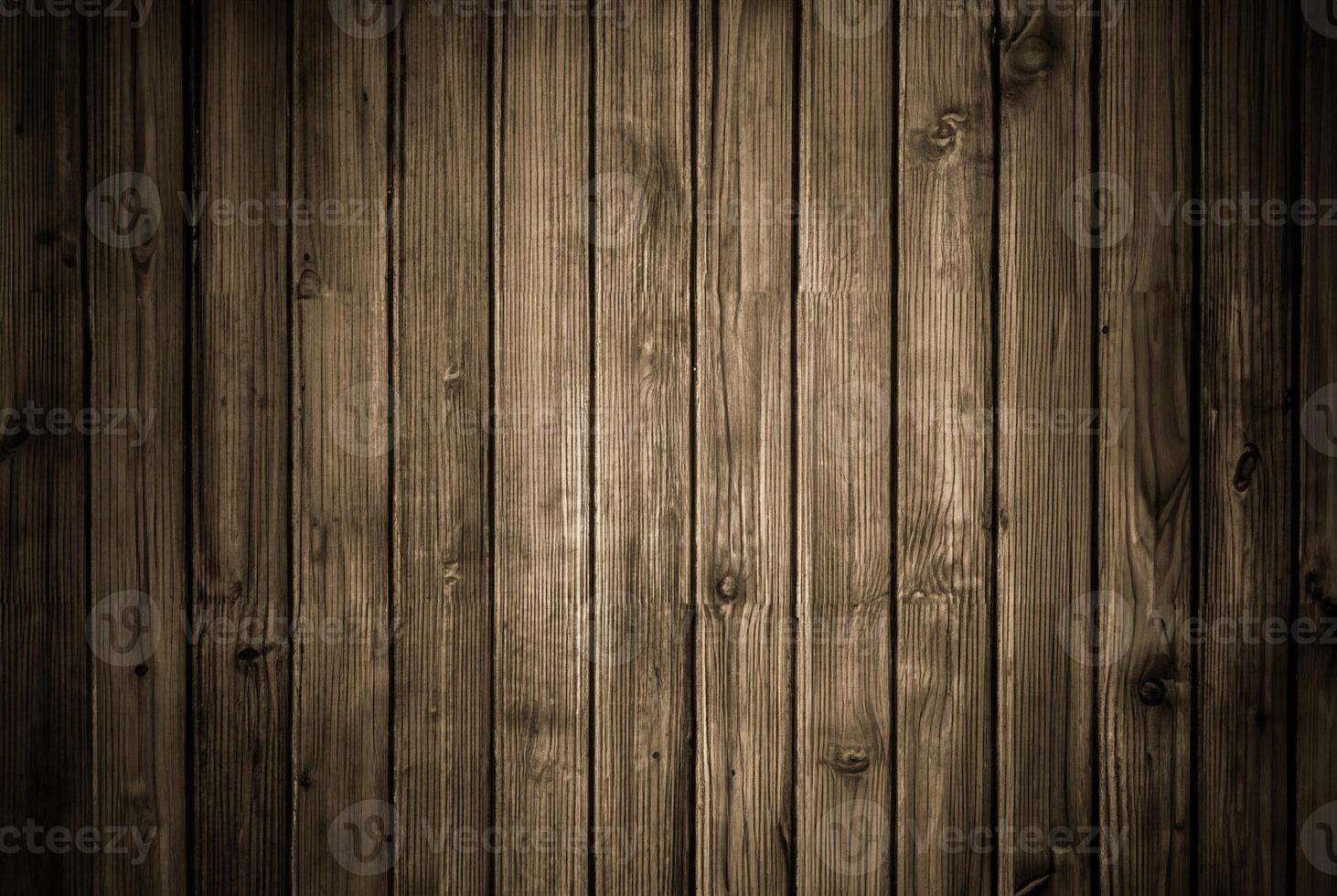 Rustic wooden plank wall with dark tones and visible vertical grain texture, ideal for backgrounds and wood-themed designs. photo