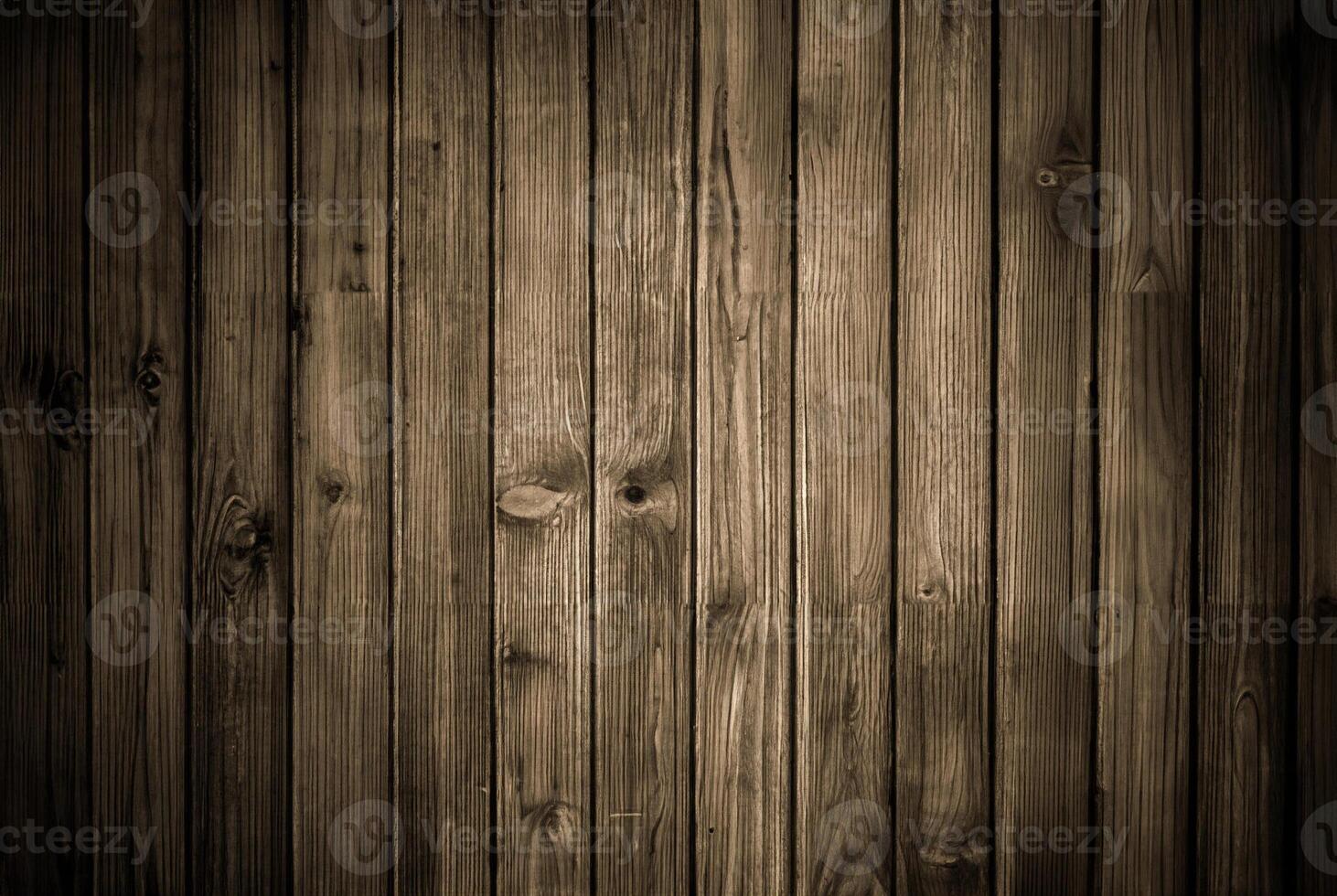 Rustic wooden plank wall with dark tones and visible vertical grain texture, ideal for backgrounds and wood-themed designs. photo