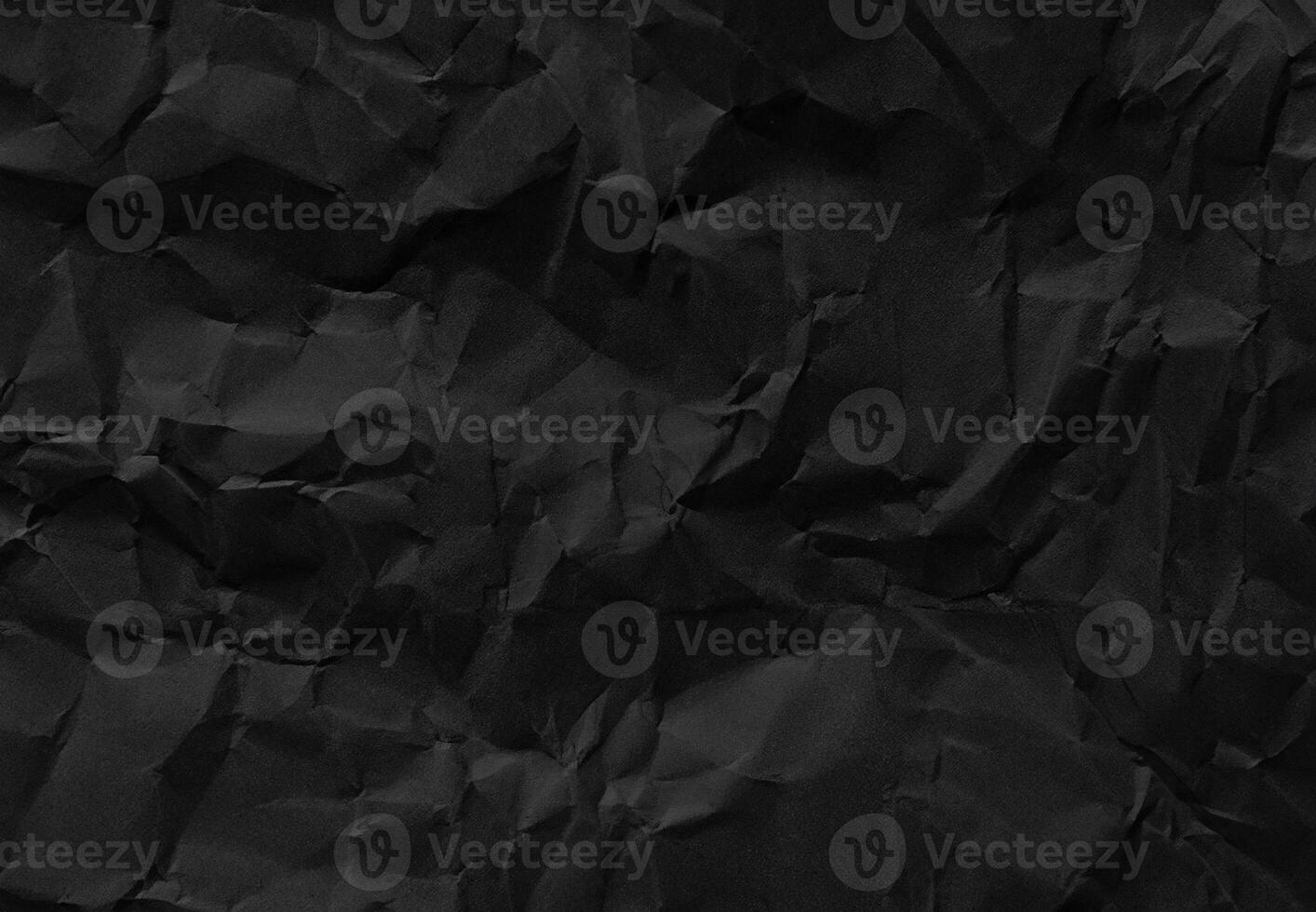 Crumpled black paper texture with wrinkles and folds, ideal for backgrounds and design elements. photo