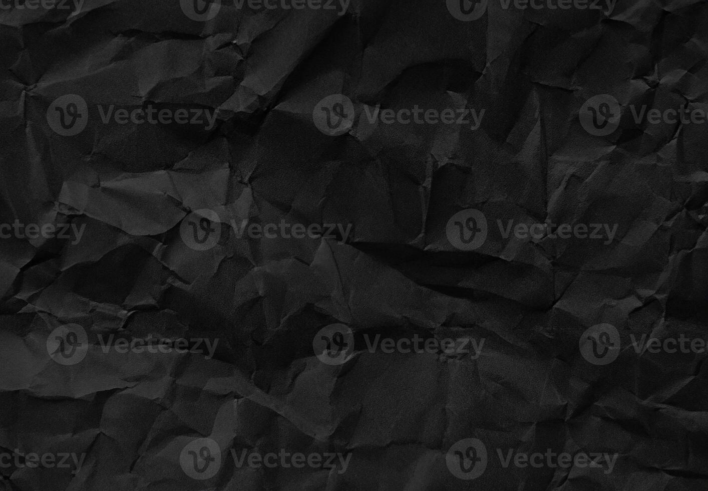 Crumpled black paper texture with wrinkles and folds, ideal for backgrounds and design elements. photo