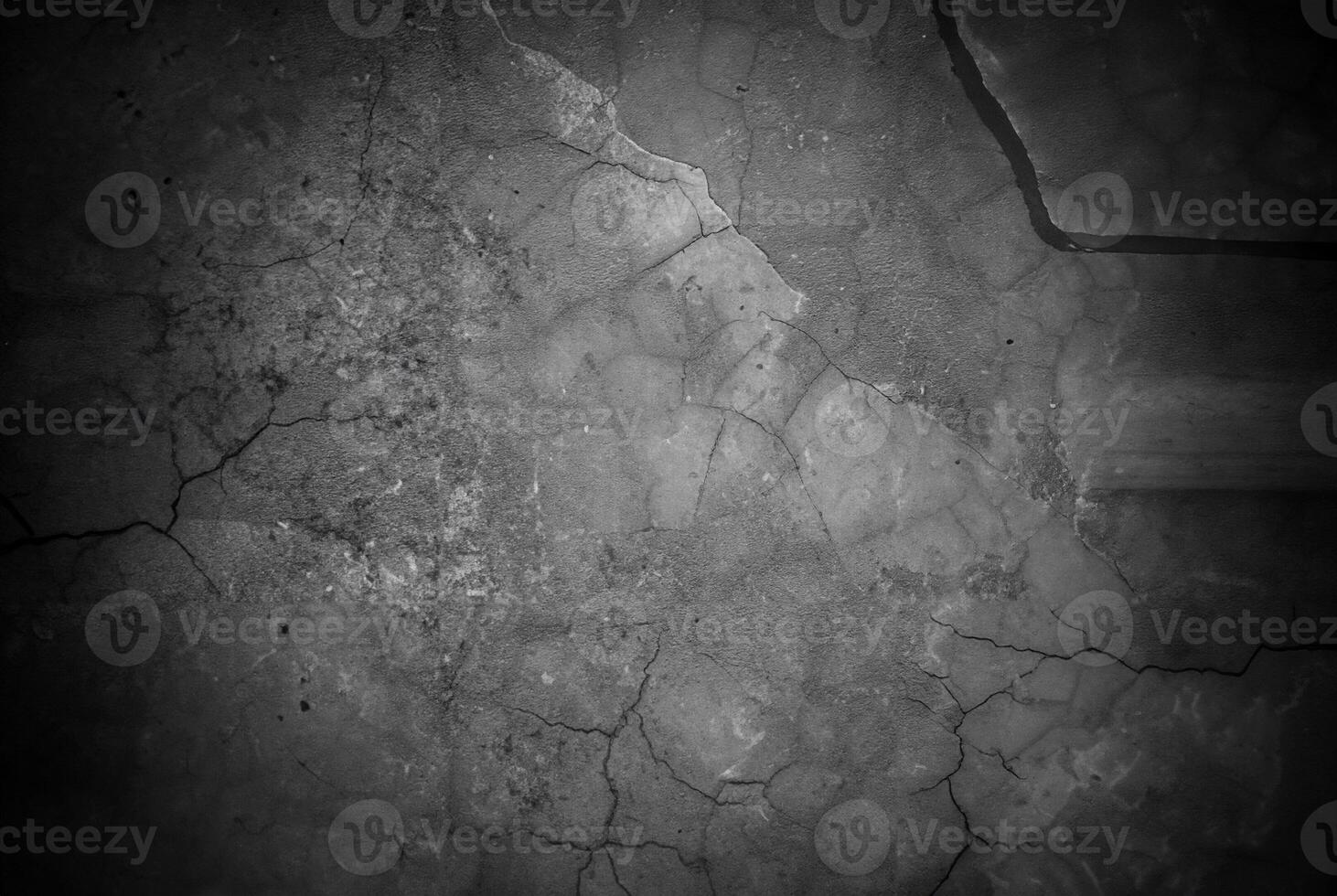 Dark cracked concrete surface with textured details and subtle lighting, ideal for backgrounds or design elements. photo