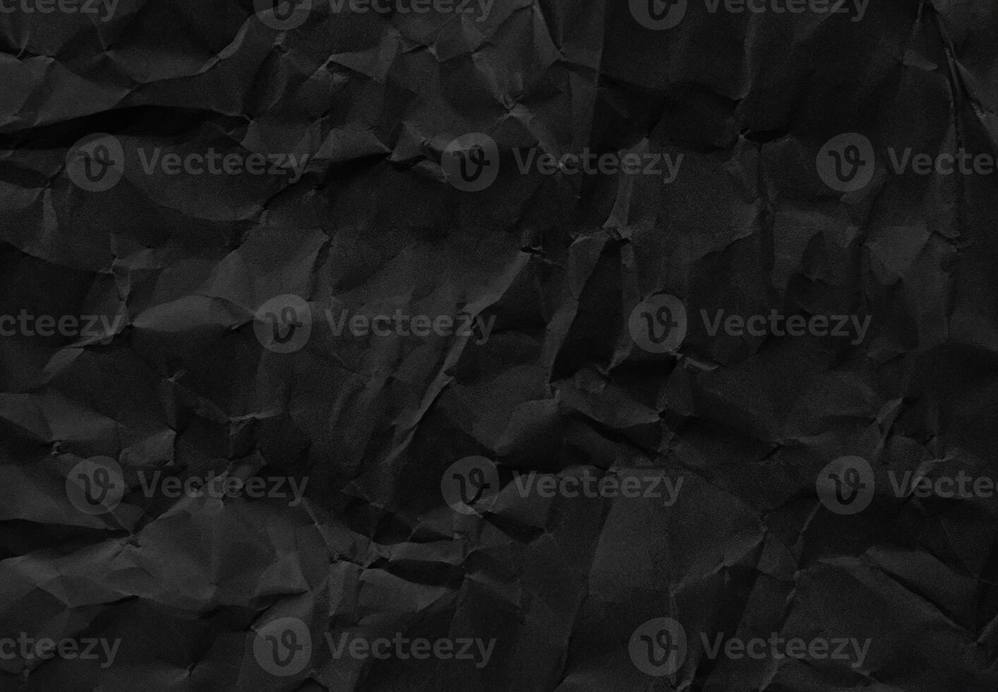 Crumpled black paper texture with wrinkles and folds, ideal for backgrounds and design elements. photo