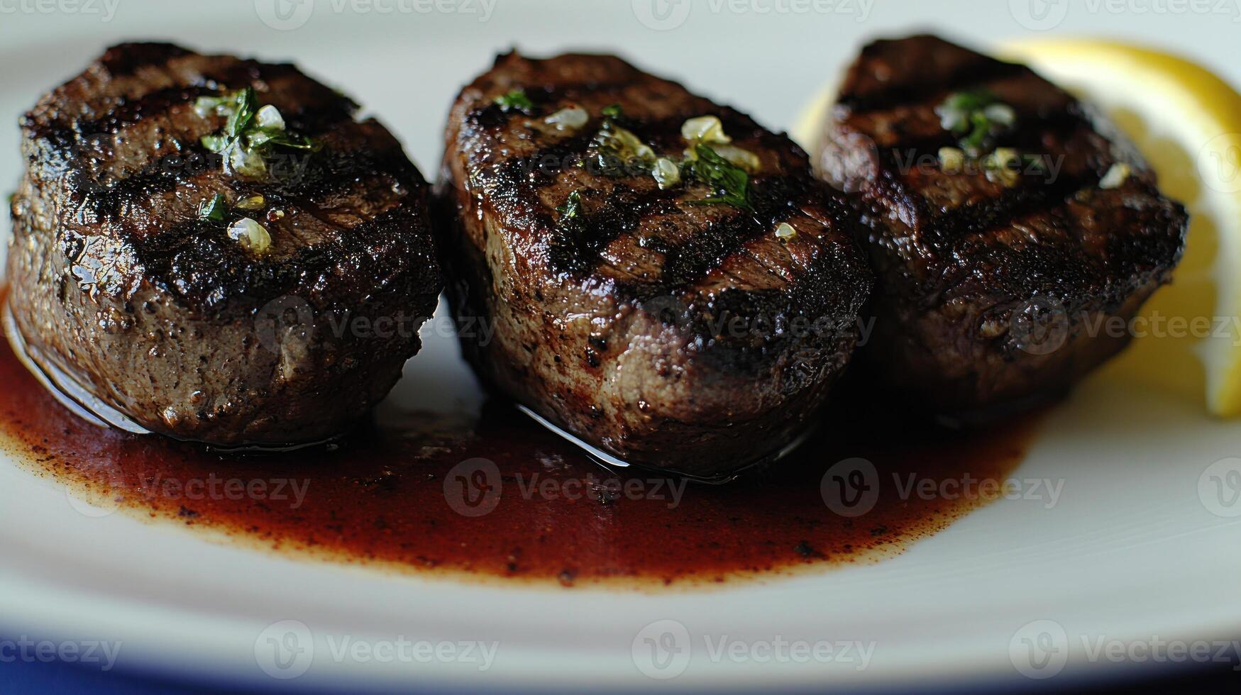 Juicy grilled steaks beautifully plated with fresh herbs and a lemon slice photo