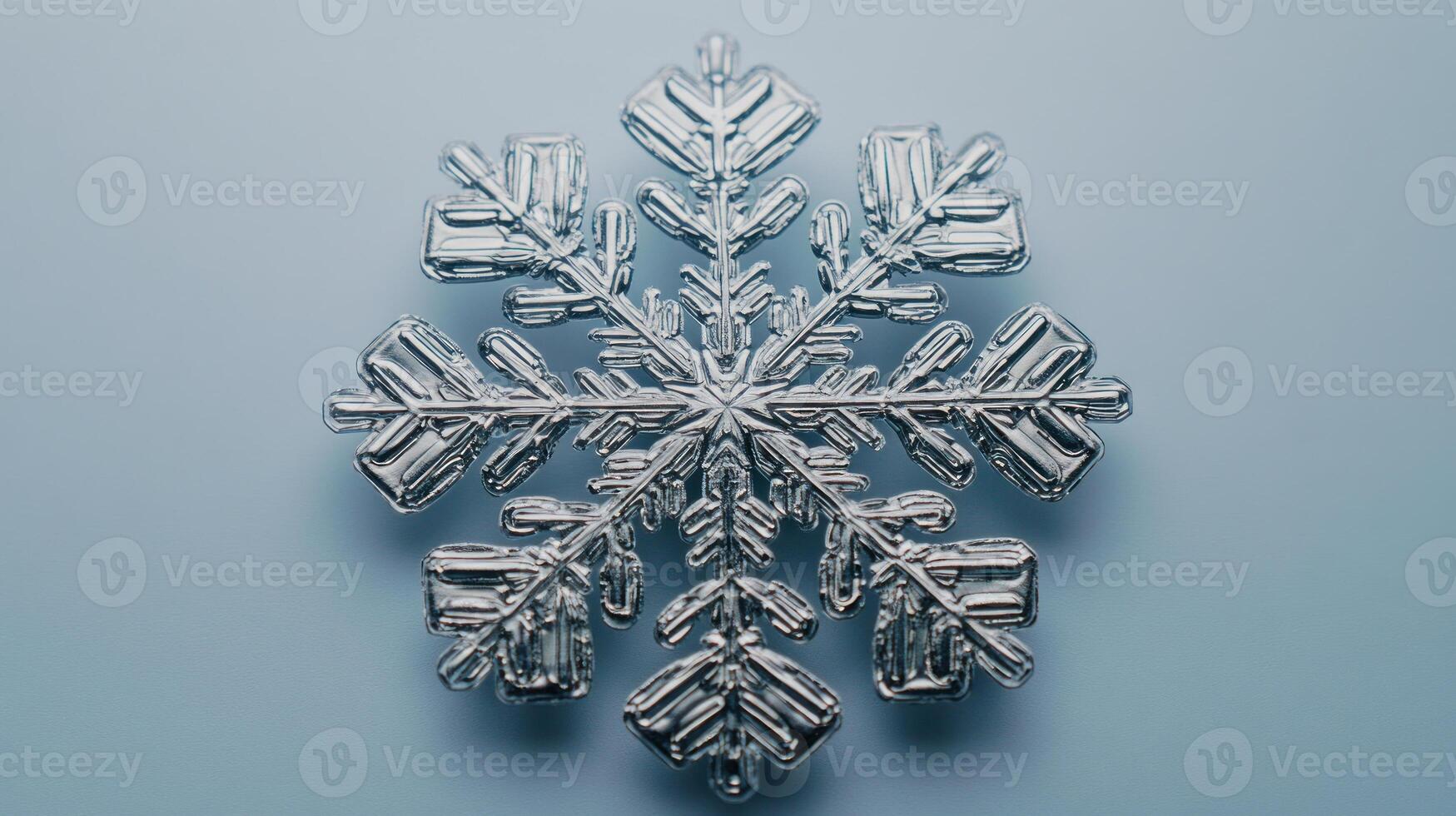 A stunning snowflake lies gracefully on a soft blue surface, showcasing nature's artistry photo