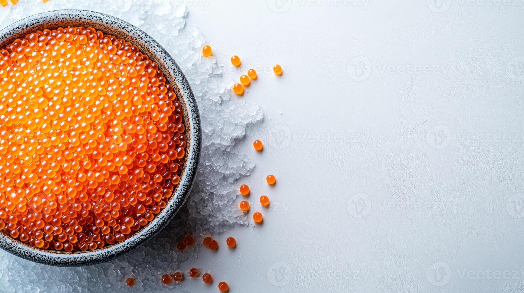 A bowl of vibrant salmon roe rests elegantly on ice, inviting a taste photo