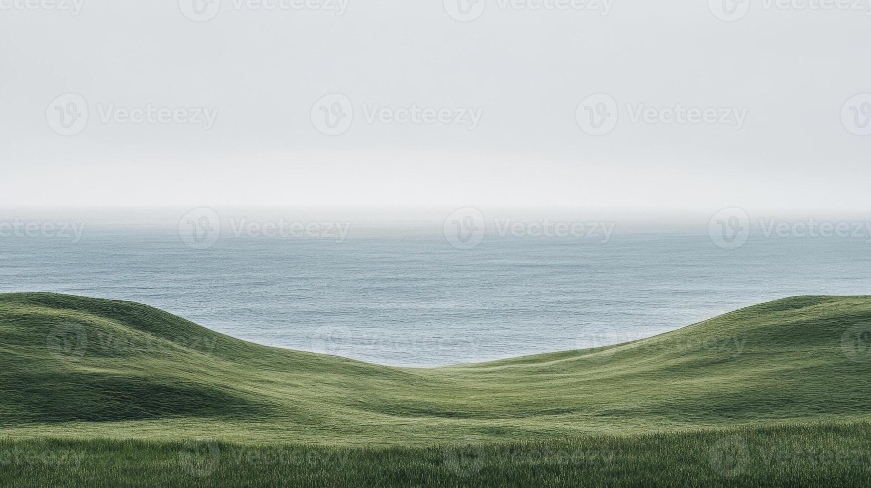 A beautiful, serene scene that showcases gentle hills gradually leading down to a calm ocean, all enveloped in soft light, surrounded by lush natural greens that create a tranquil atmosphere photo