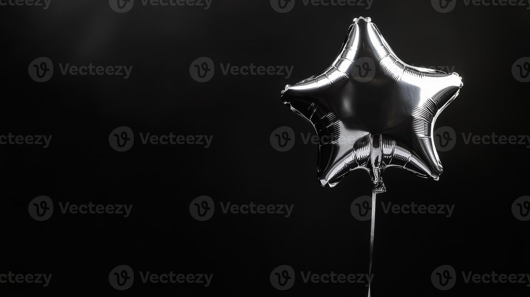 A shiny silver starshaped balloon floats against a deep black background, creating a festive atmosphere that enhances the charm of any special occasion, making it even more memorable photo