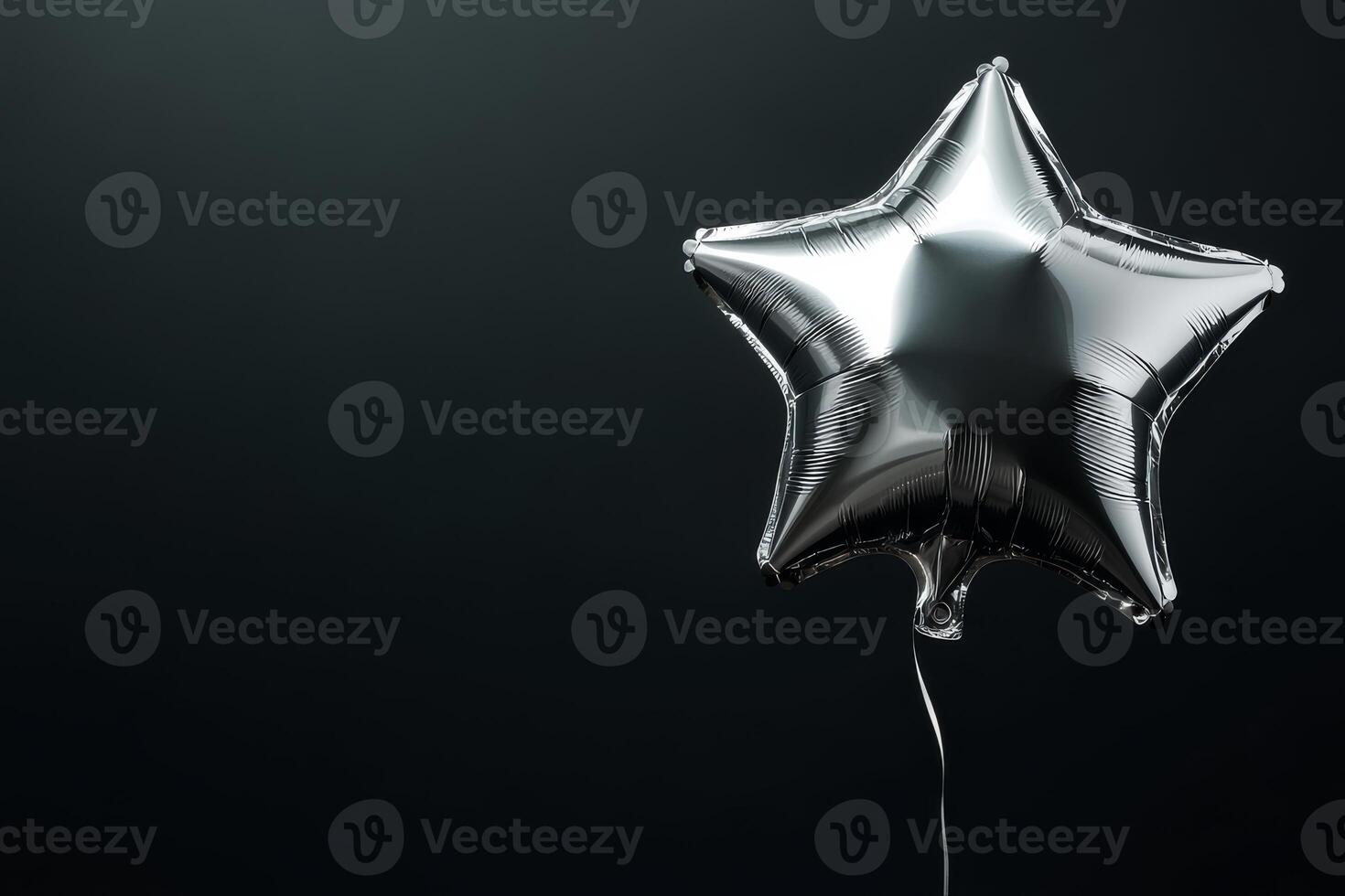 A gleaming silver starshaped balloon floats gracefully against a deep black backdrop, illuminated by soft, gentle light, creating a striking visual contrast that captivates the viewers attention photo