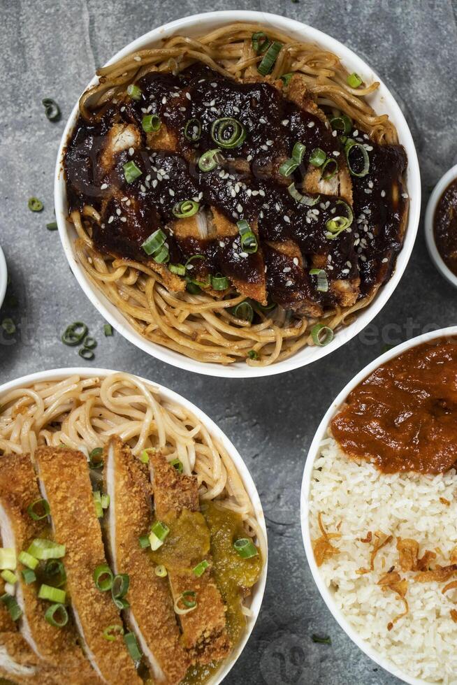 Teriyaki Grilled Chicken Noodles, Katsu Chicken Noodle, Butter Chicken with Rice served in bowl isolated on grey background closeup top view of assorted japanese food verity assortment photo