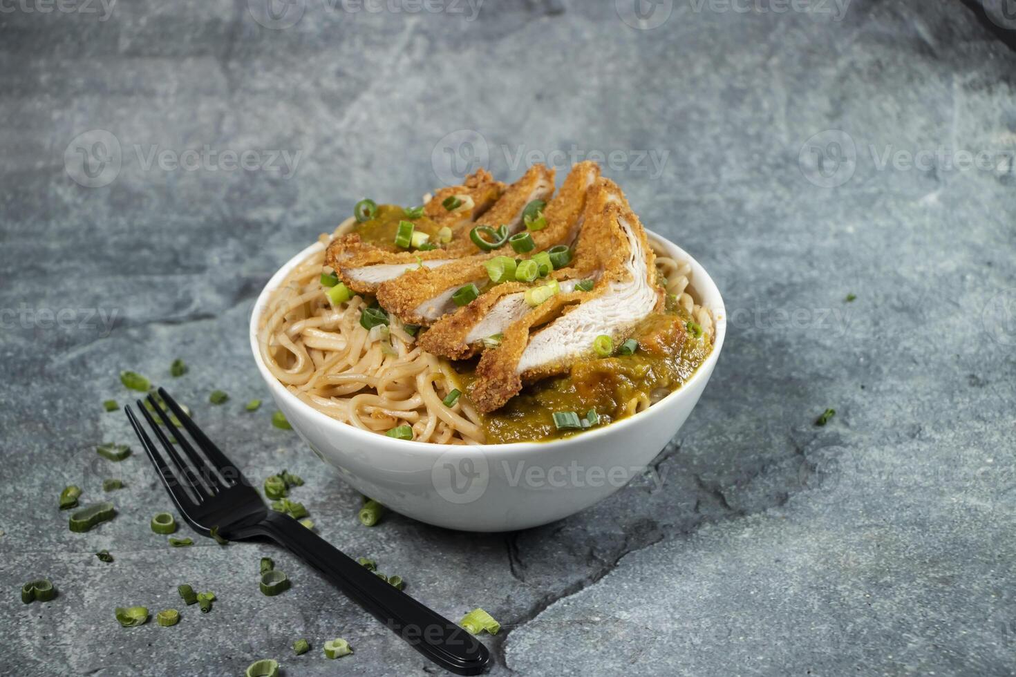 Katsu Chicken Noodles with green onion and fork served in bowl isolated on grey background side view of asian food photo