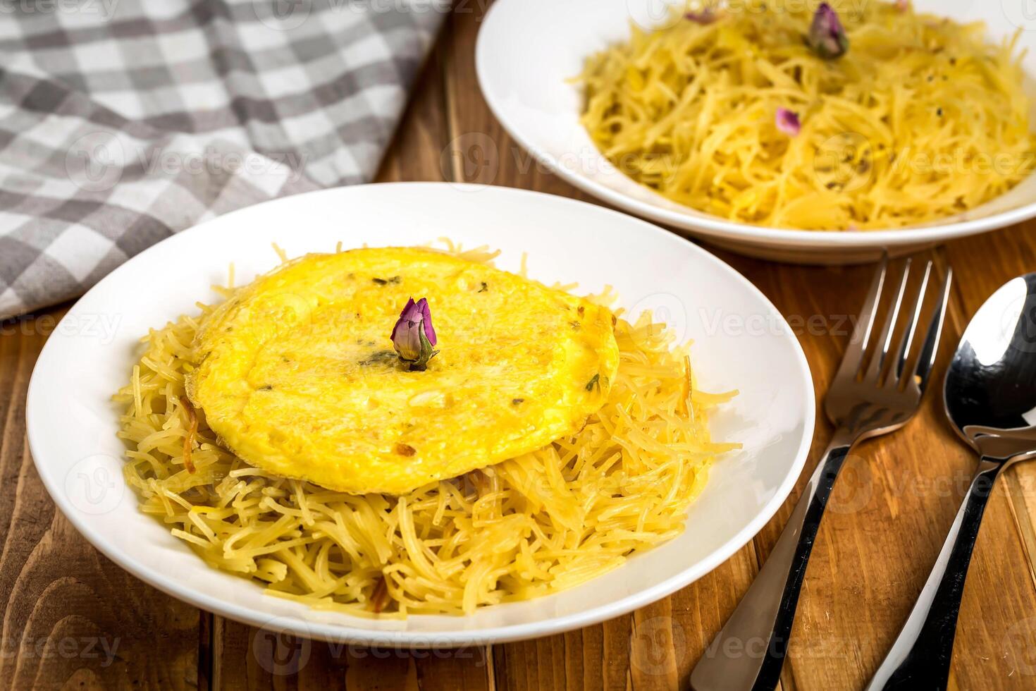 Balaleet with Egg, spoon and fork served in plate isolated on wooden table side view of traditional Middle Eastern food photo
