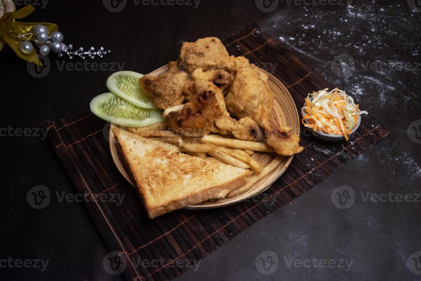 Chicken Drumstick with French Fries, Toasted Bread and Salad served in wooden plate isolated on dark background side view of bangladeshi fast food photo