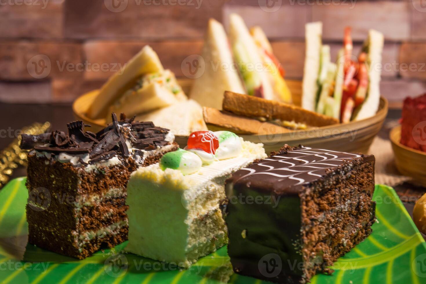 Assorted cakes, Club Sandwich, Toasted Bread, isolated on table closeup side view of Bangladeshi food photo