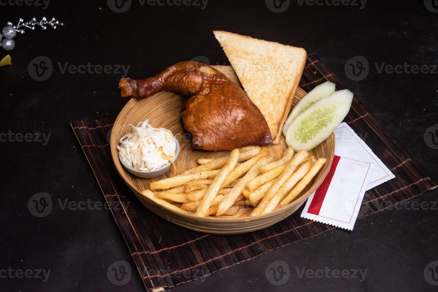 smoked chicken quarter with French Fries, Toasted Bread and Salad served in wooden plate isolated on dark background side view of bangladeshi fast food photo