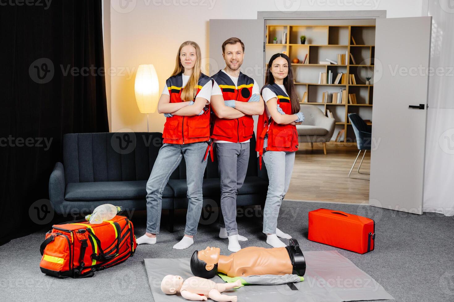 Group of people with cpr dummy looking at camera and smiling after first aid training class photo