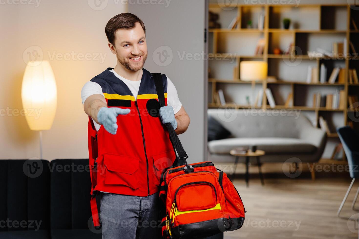 First aid course. A young male paramedic with a bag on his shoulders is standing in a classroom before a lecture photo