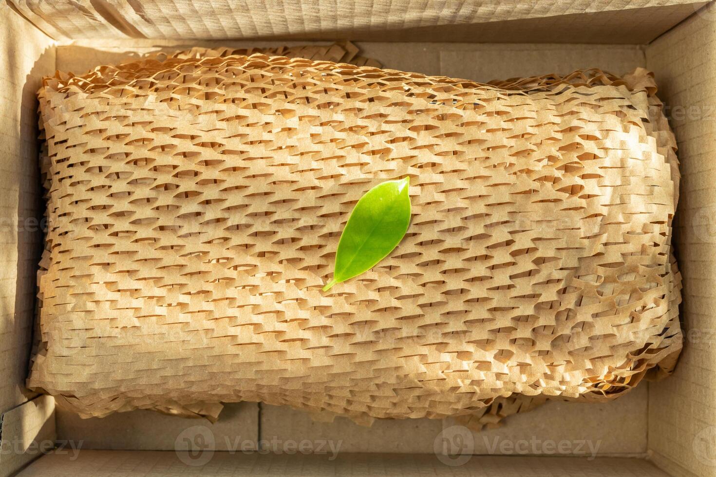 Green leaf on eco friendly brown paper honeycomb wrap for product packaging parcel carton box photo
