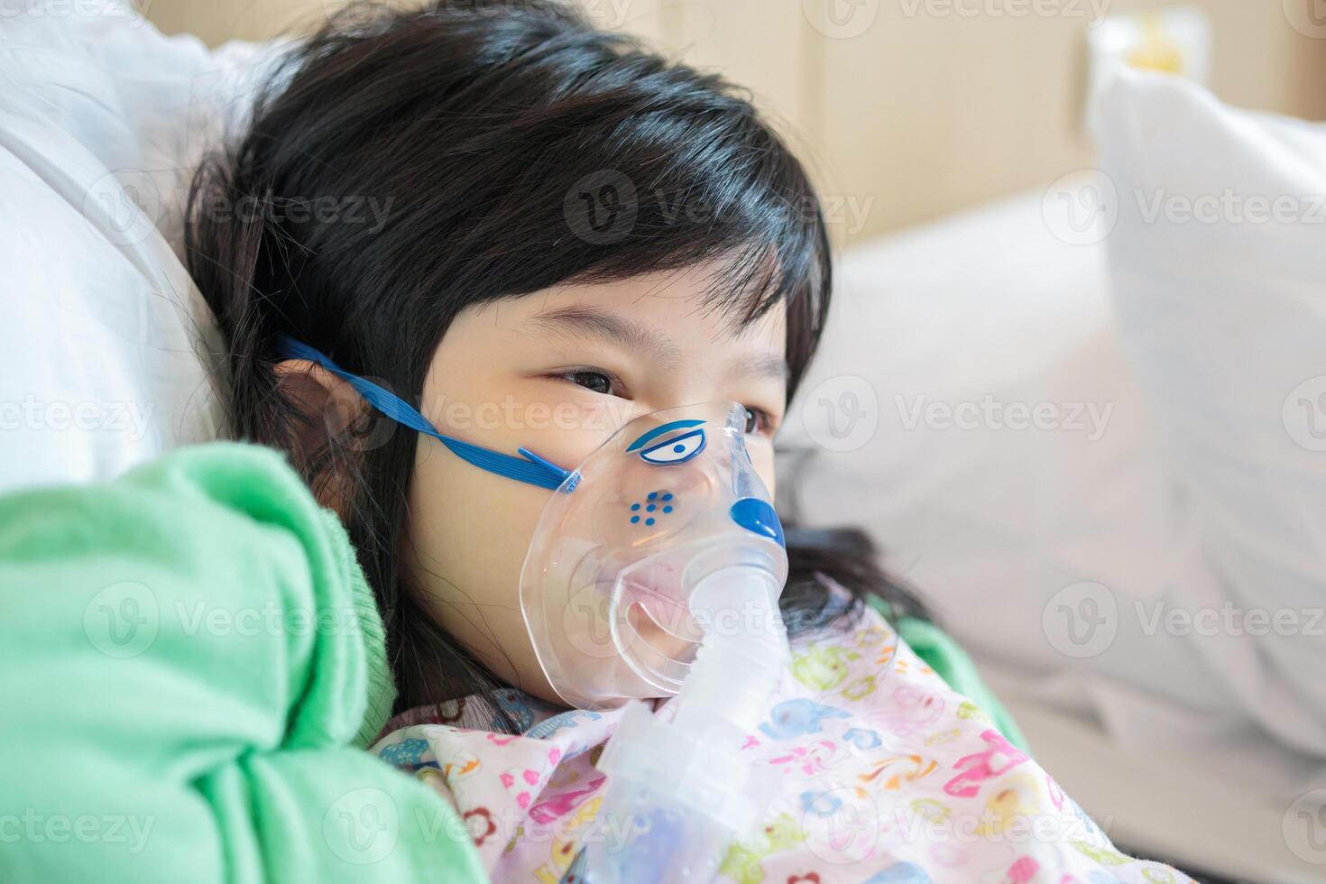 Sick little asian girl inhalation with nebulizer for respiratory treatment photo